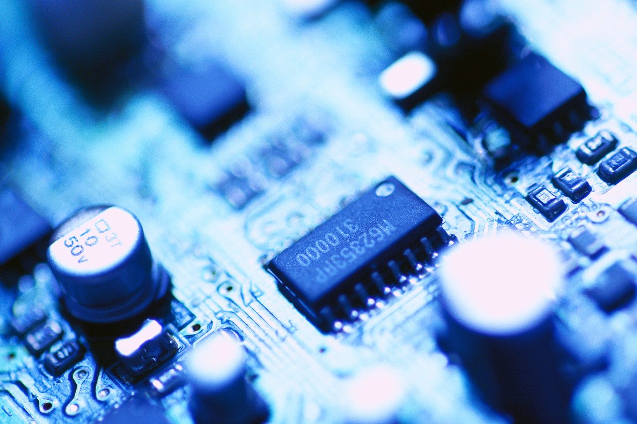 electronics Close-up of a blue circuit board with microchips and electronic components.