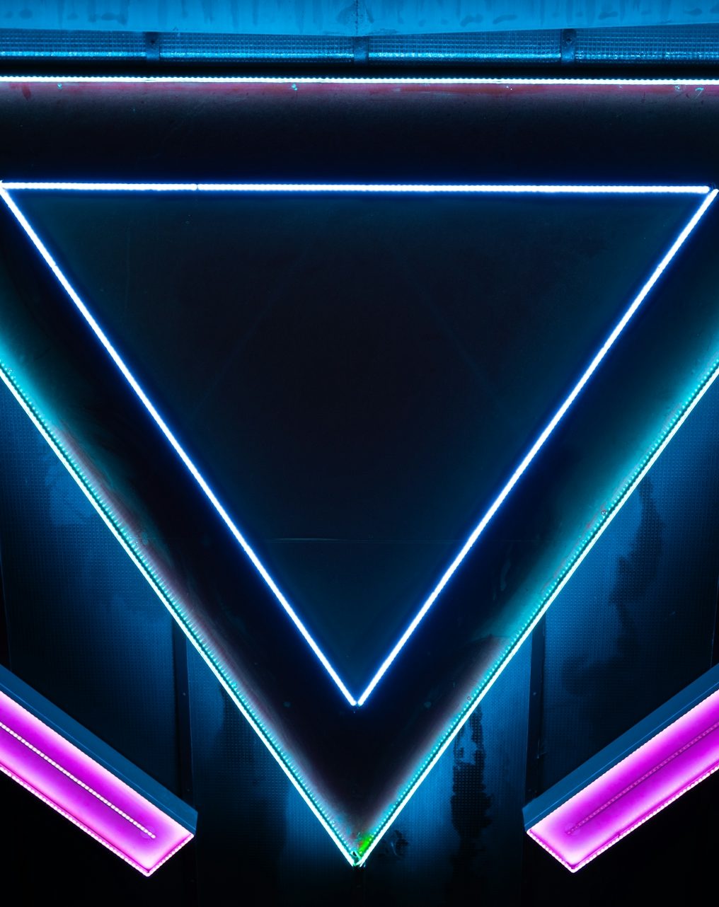 hone in Neon geometric shapes with a triangle and glowing edges in blue and purple tones.