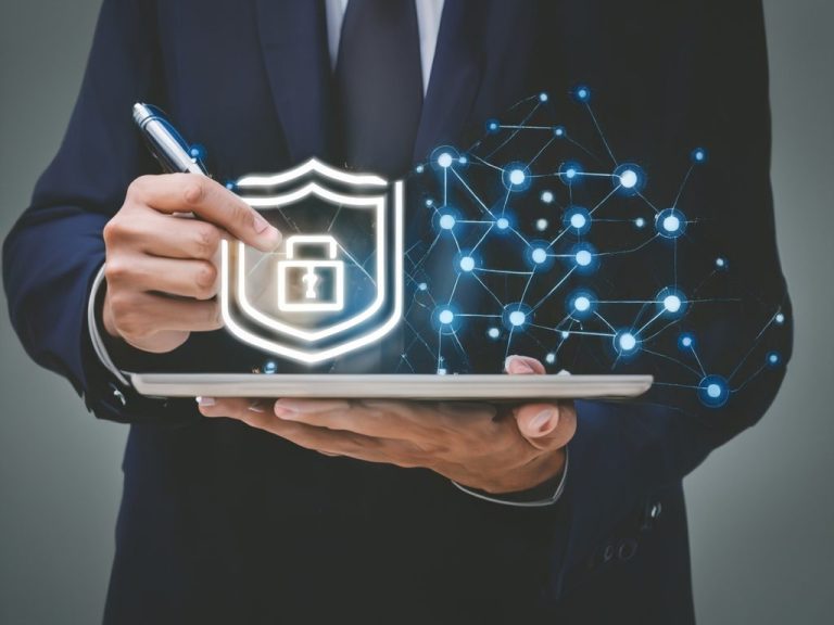 Information Security Person holding a tablet, drawing a lock symbol to represent cybersecurity.